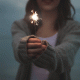 girl holding sparkler dark background