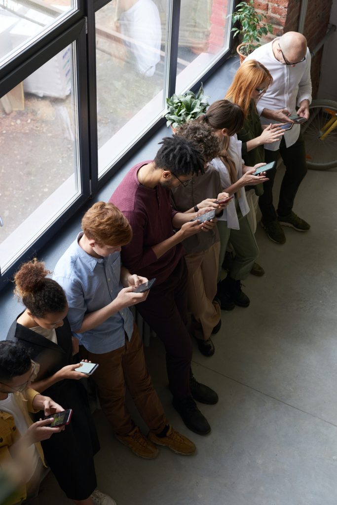 line of people texting on their phones