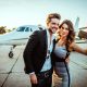 Rich and famous couple taking a selfie for social media while embracing each other in front of a private airplane parked on a tarmac