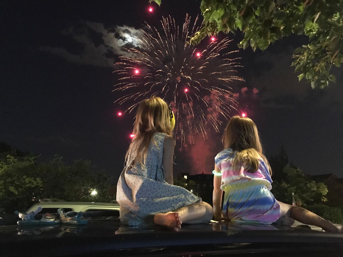 girls on the hood of a car watching fireworks for the 2023 fireworks blog post on sandy hibbard creative